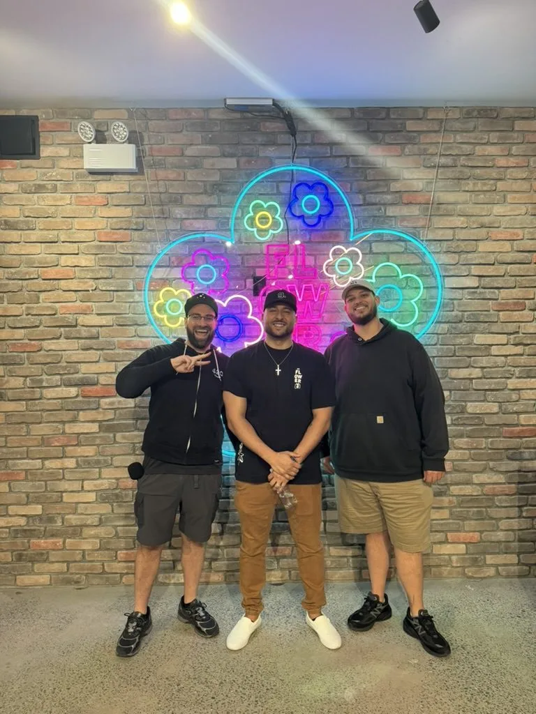 Gold Standard Solutions founder with dispensary clients at Flower neon sign cannabis event