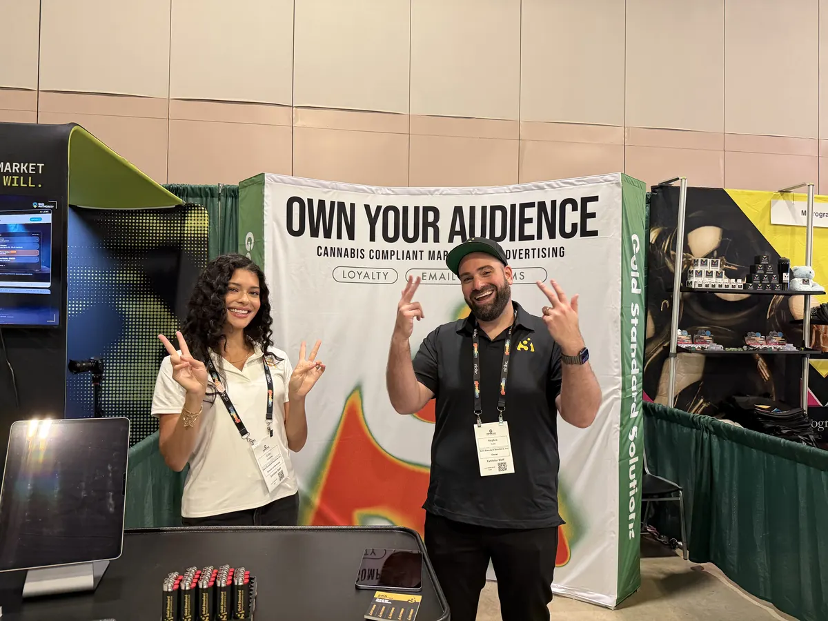 Stephen Gold and Gaby at cannabis expo booth with Own Your Audience banner
